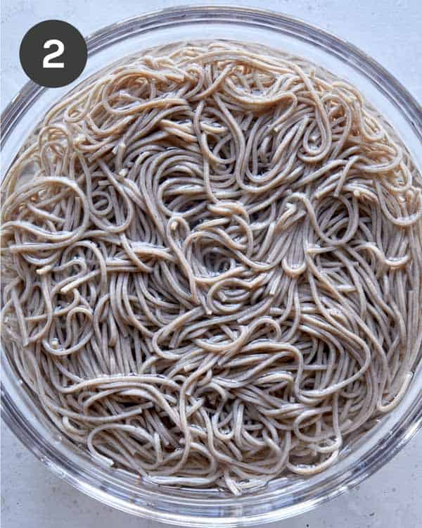 Soba noodles soaking in a bowl with water.